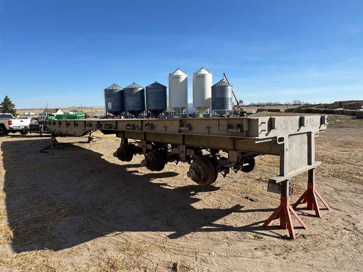 Hay trailer beside grain bins on a southeast Alberta farm