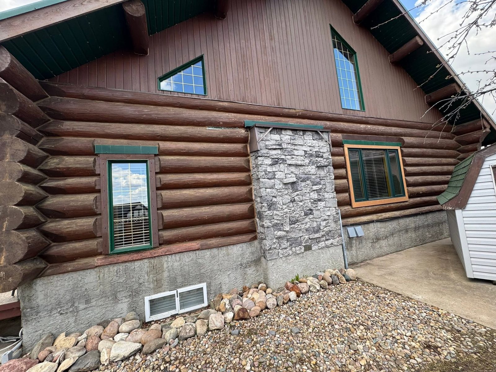 Log home with dark failing stain before restoration
